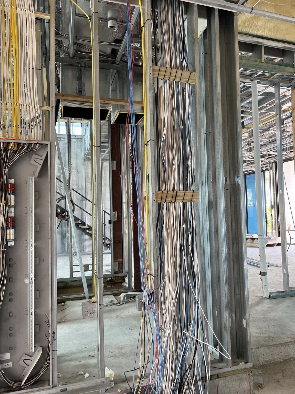 Smart-home prewire cable bundles routed through steel framing beside lighting enclosures in Boca Raton.