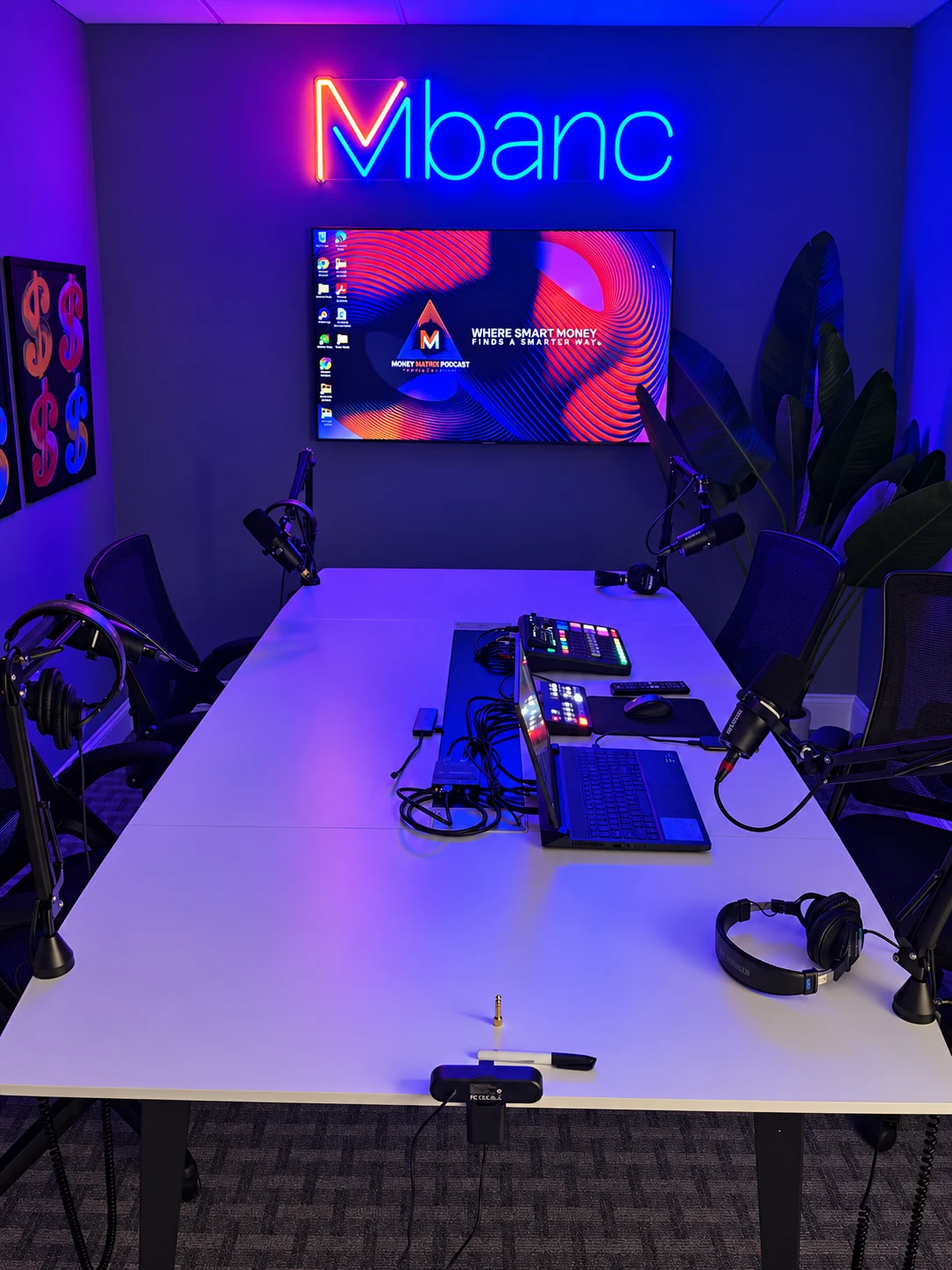Completed office podcast studio with blue ambient lighting, microphones and production equipment