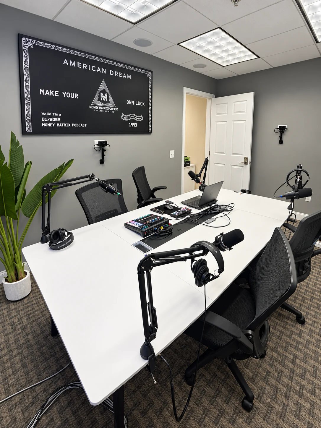 Podcast studio microphone arms, headphones, laptop and tabletop audio and video production controls